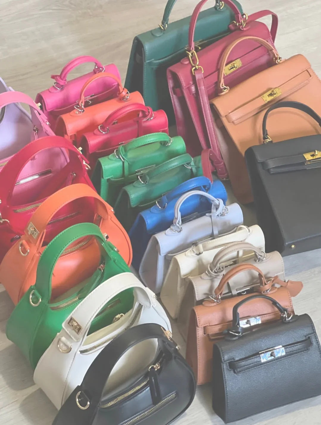 Collezione di borse eleganti e colorate Les Soeurs 33 disposte su pavimento chiaro