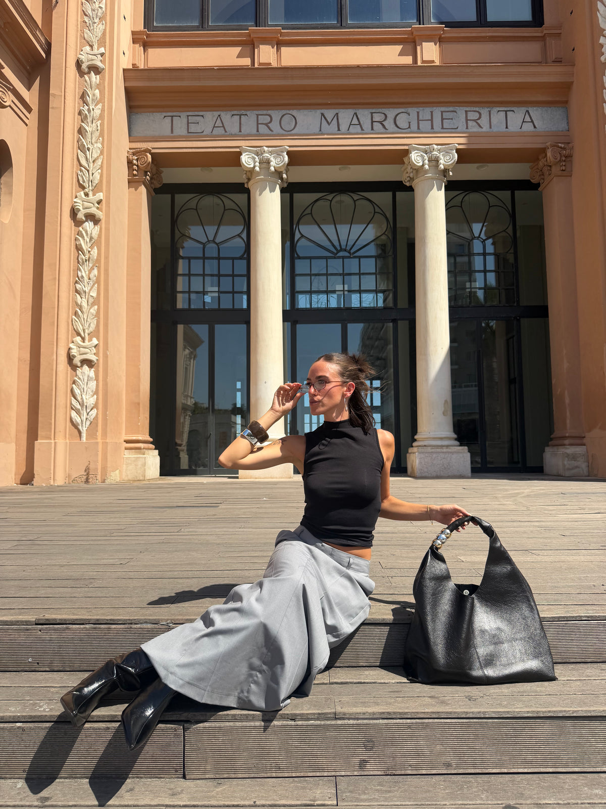 borsa monaco con outfit magli nera gonna e tacco nero in cento città 