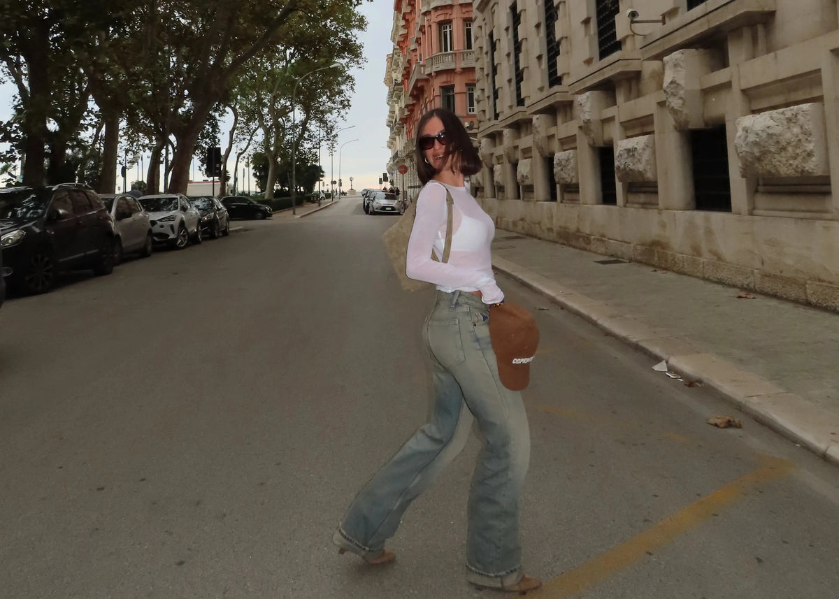 outfit Borsa Kaila khaki con Jeans maglietta bianca trasparente cappellino cuoio stivale con tacco in centro città