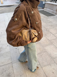 outfit con borsa Olivia indossata con giubbotto jeans e stivali 